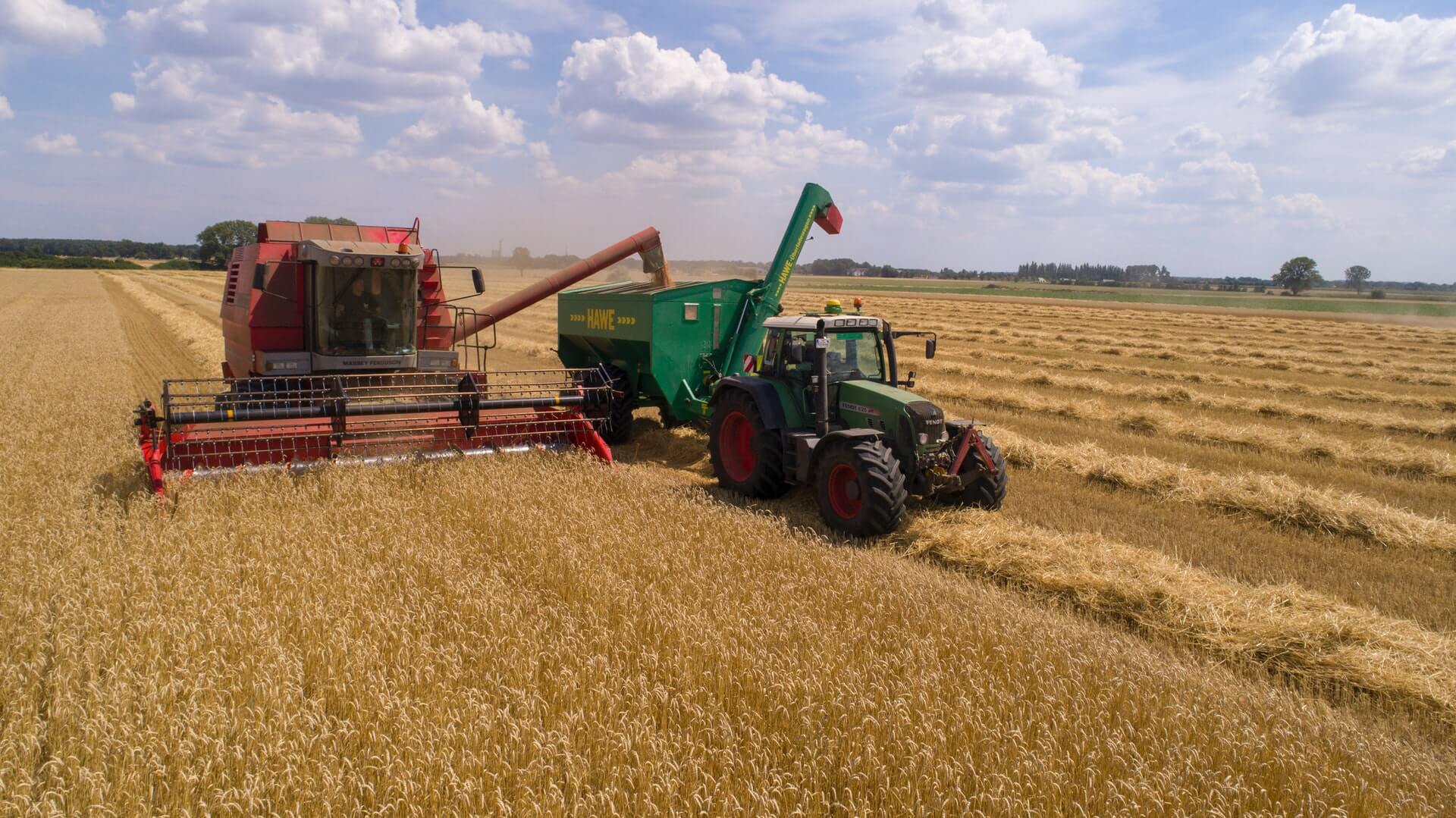 Mähdräscher und Traktor auf Feld; Source: Photo by Heiko JANOWSKI (https://unsplash.com/@blixxmagger) on Unsplash